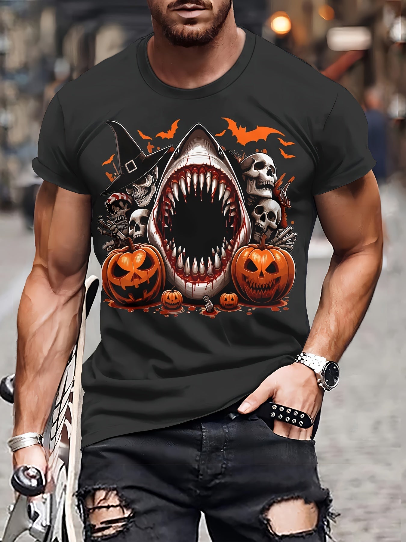 Person wearing a black t-shirt with a Halloween-themed design featuring a shark, pumpkins, and skulls.